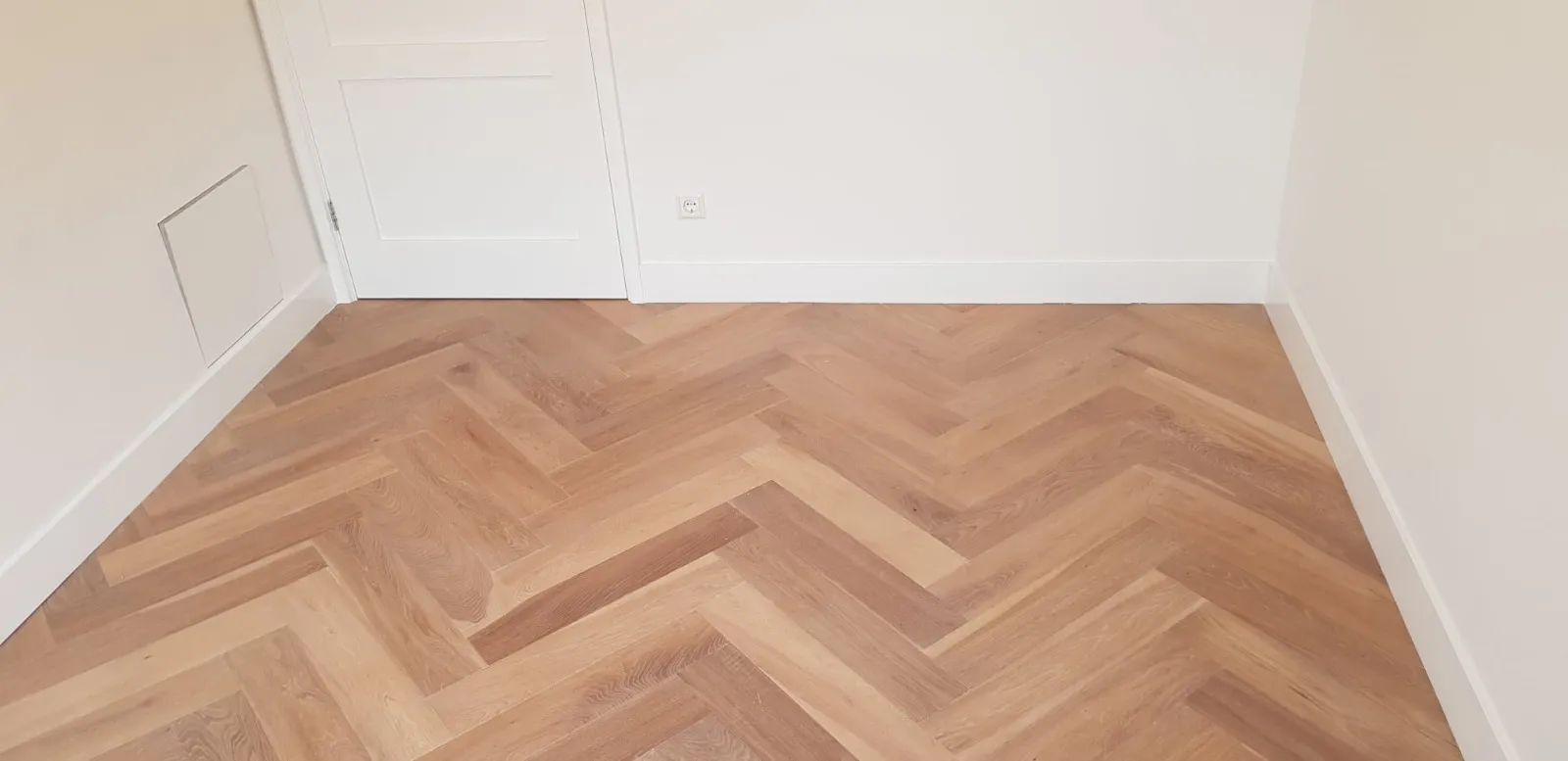 Visgraat parketvloer in gerenoveerde kamer
