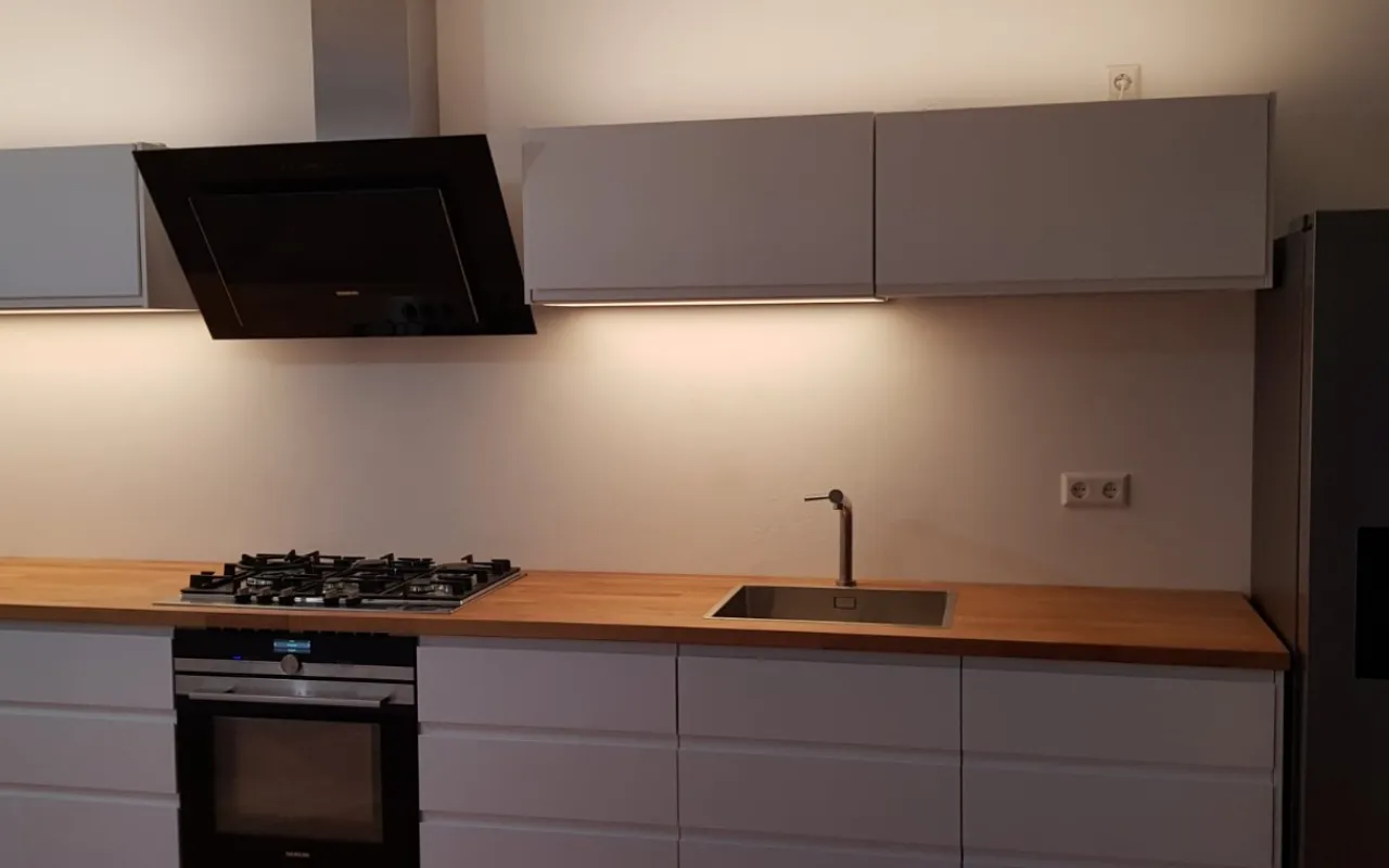 Strakke grijze keuken met houten werkblad