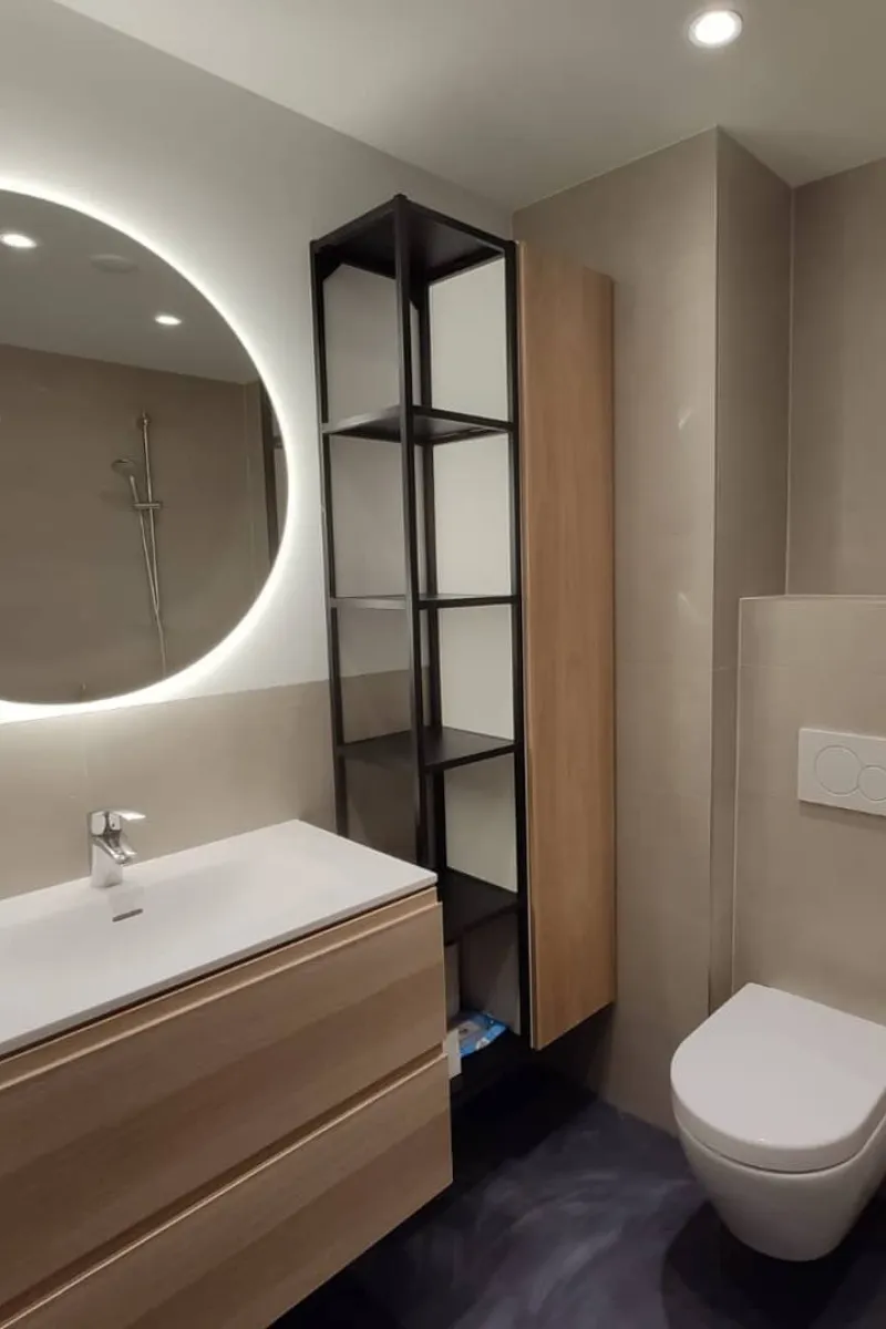 Moderne badkamer met ronde spiegel en houten meubel